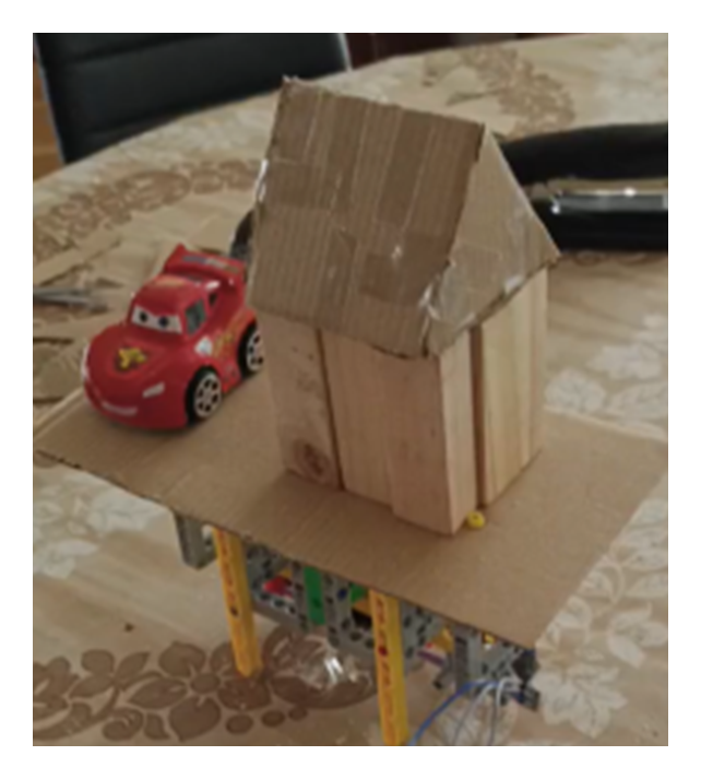 Casita LEGO sobre una plataforma con servo Arduino que se sacude al hacer clic en un terremoto del mapa. Tercer nivel del experimento — la fisicalización. La intensidad de un sismo deja de ser un número (8,8 grados) para convertirse en algo que vibra en tu escritorio. El dato se convierte en experiencia, y por eso se recuerda.